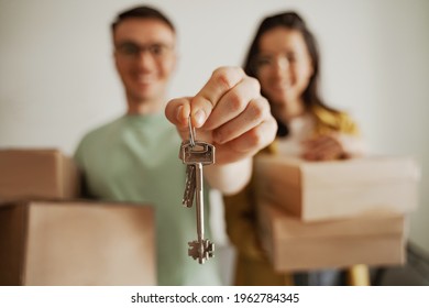 Close up happy couple holding keys of new apartment with boxes. Young family moving to new apartment - Shutterstock ID 1962784345