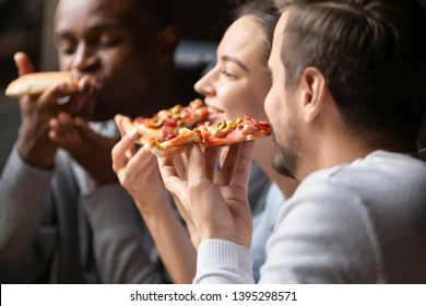 Close Up Happy Diverse Friends Eating Pizza In Cafe Together, Biting Slices, Multiracial People Enjoying Italian Junk Food At Meeting In Cafeteria, Having Fun Together, Satisfied Customers