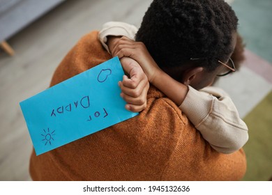 Close Up Of Happy Father Embracing Little Girl After Coming Home From Work On Fathers Day, Focus On Child Holding Letter For Dad, Copy Space