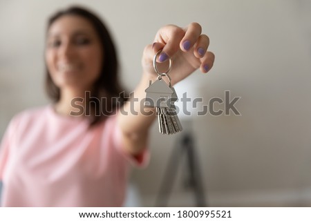 Close up of happy female renter tenant show keys buy purchase first own home or apartment, woman moving relocating to new dwelling, excited client settle in house, relocation, rental, realty concept