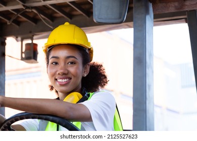 Close Up Happy Female Worker Driving Forklift African-American Woman With Safety Uniform And Yellow Hard Hat  Driving Forklift And Work At Warehouse Container Shipping Construction Site Import Export.