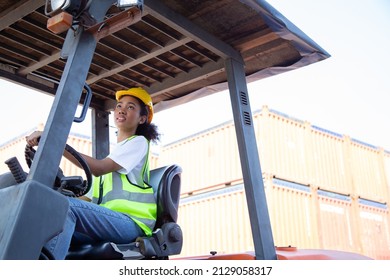 Close up happy female worker driving forklift African-American woman with safety uniform and yellow hard hat  driving forklift and work at warehouse container shipping construction site import export. - Powered by Shutterstock