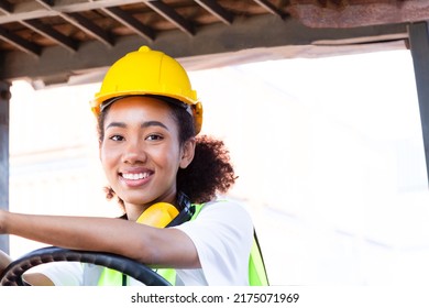 Close Up Happy Female Worker Driving Forklift African-American Woman With Safety Uniform And Yellow Hard Hat Driving Forklift And Work At Warehouse Container Shipping Construction Site Import Export.