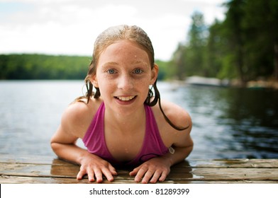 close up of a happy girl on a cottage dock at the lake
