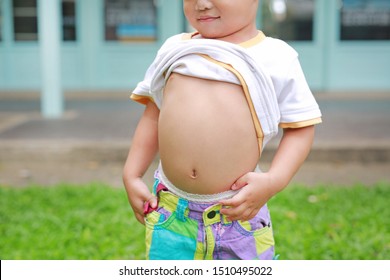 Close Up Happy Little Boy Lifting His Shirt Show Exposing His Big Tummy.