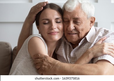 Close up of happy mature father hug cuddle grownup daughter enjoy tender family moment at home, caring elderly dad embrace show love and affection to adult child, share sweet weekend together