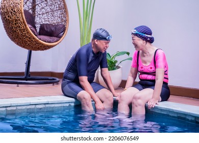 Close Up Of Happy Old Couple Wearing Swimwear While Chatting Together And Sitting On The Poolside