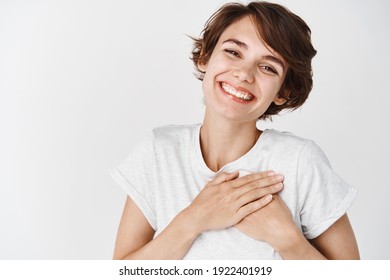 Close Up Of Happy Smiling Woman Say Thank You, Holding Hands On Heart Grateful, Express Gratitude, Standing Against White Background.