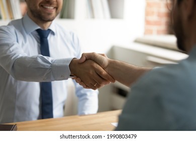 Close Up Happy Two Business Men Shaking Hands, Coming To Agreement After Negotiations Meeting. Smiling Employer Welcoming Job Applicant At Interview In Office, Making Offer, Recruitment Concept.