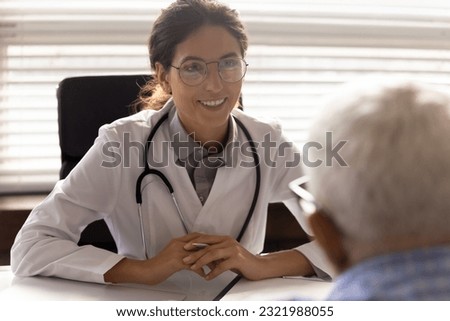 Close up of happy young Caucasian female GP in white uniform talk consult elderly male patient. Smiling woman doctor have consultation with old man client in hospital. Geriatrics, healthcare concept.