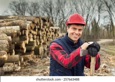 Close up of happy young lumberjack with ax beside cut trunks in forest  - Powered by Shutterstock