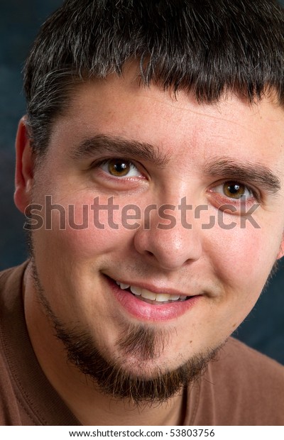 Close up of a happy young man\'s face with a beard\
and soul patch.