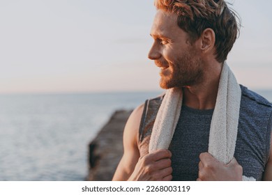 Close up happy young strong sporty athletic toned fit sportsman man in sports clothes towel warm up train look aside at sunrise sun dawn over sea beach outdoor on pier seaside in summer day morning. - Shutterstock ID 2268003119