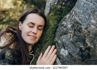 Close Up Of Happy Young Woman Gently Touch Tree Bark Covered In Green Lush Moss At Autumn Day. Forest Conservation, Saving Environment, Green Movement. Saving Planet And Connection With Nature Concept