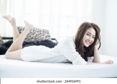 Close Up Of A Happy Young Woman Smile While Lying On The Bed At Home , Model Is A Asian Girl