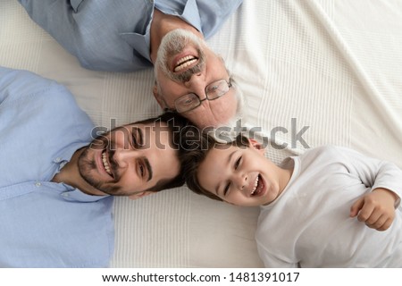 Close up head to head above view three cheerful faces looking pose for camera grandfather grown up son and little adorable grandkid, different multi generational beautiful men family portrait concept