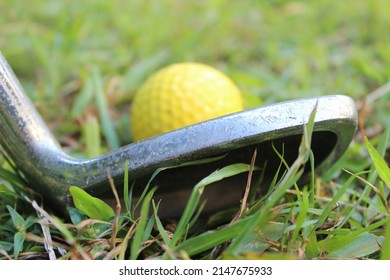 Close Up Of The Head Of A Golf Club And A Yellow Golf Ball