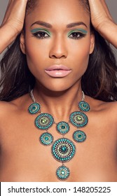 Close Up Head Portrait Of A Beautiful African Fashion Model Wearing A Striking Ethncs Necklace Posing With Her Hands To Her Hair