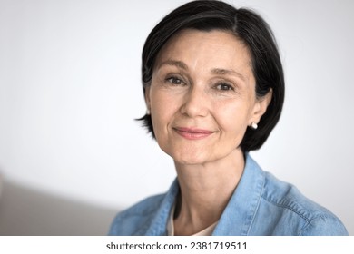 Close up head shot good-looking mature woman with short hair pose indoors. Portrait of retired female, having attractive appearance, advertises anti-age cosmetics or treatment. Natural beauty, wisdom - Powered by Shutterstock