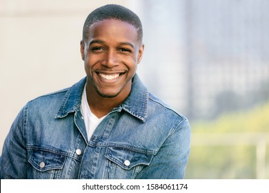 Close up head shot of a handsome commercial african american model with perfect white teeth smile after dentist, dental and orthodontic advertisement