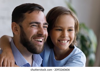 Close Up Head Shot Happy Bonding Caring Young 30s Father And Small Cute Teen Kid Son Having Fun Looking In Distance, Laughing Watching Entertaining TV Shows Series Cartoons Together At Home.