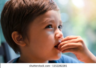 Close Up Head Shot Of Hungry Little Boy Eating Scampi, Selective Focus Of Child Putting Scampi In His Mouth, CLose Up Side View Of Kid Face Enjoy Eating Food With Blurry Bokeh Background