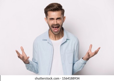 Close up head shot image of furious handsome bearded man screaming and looking at camera. Mad young male quarreling blaming anybody, shouting, feeling aggression on gray background, conflict concept - Shutterstock ID 1564188934