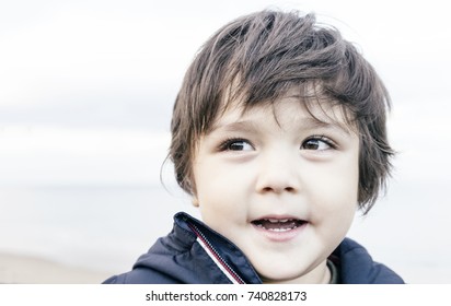 Close Up Head Shot Of Little Kid With A Smiling Eyes Looking Out At Sky By The Sea In Retro Tone, Toddler Boy Enjoying The Time At The Sea On Holiday,Children Outdoors Activities With Parent Concept