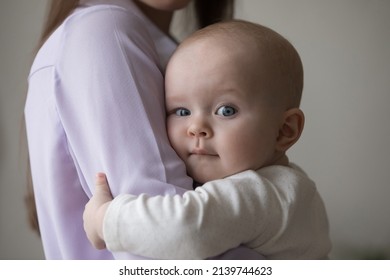 Close Up Head Shot Loving Young Woman Cuddling Sweet Adorable Small Newborn Baby Toddler Boy Or Girl With Big Grey Eyes, Expressing Sincere Feelings, Enjoying Tender Moment, Childhood And Motherhood.