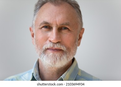 Close up head shot portrait of handsome pleasant bearded middle aged mature hoary retired man posing on grey white wall. Elderly wrinkled male client satisfied with services, retirement life concept. - Powered by Shutterstock