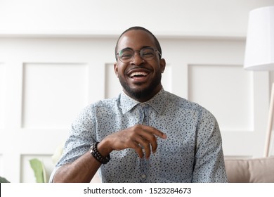 Close up head shot portrait of happy african american man in eyeglasses looking at camera, young smiling black male blogger influencer recording video, talking, laughing, having fun at home. - Powered by Shutterstock