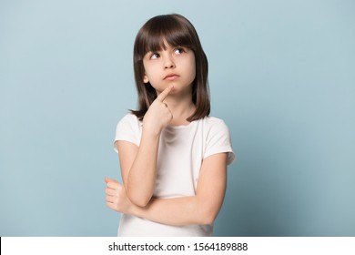 Close Up Head Shot Portrait Image With Planning Little Girl. Concept Serious Kid Holding Chin And Thinking About Dilemma On Blue Background, Six Year Child Looking Up, Gesturing, Holding Hand On Chin