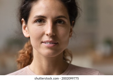 Close up head shot view attractive young 30s authentic woman with perfect skin looking at camera. Portrait of happy pleasant millennial caucasian hispanic latin confident lady with natural beauty.