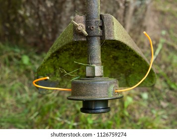 A Close Up Of The Head Of A Weed Whacker With Cut Grass On It