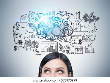 Close up of a head of a woman standing near a gray wall with a brain sketch with gears and a startup drawing. Toned image