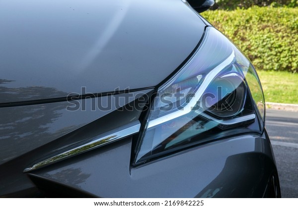 Close up of\
headlight of a black utility\
car.
