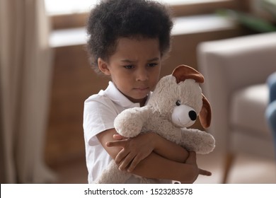 Close up headshot cute adorable sad african american little boy embracing soft toy, hurt upset offended sensitive kid looking aside feels lonely, family conflicts, parents divorce concept. - Powered by Shutterstock