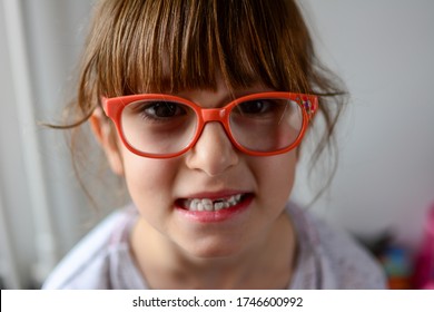 Close Up Headshot  Little Preschool Cute Girl Widely Smiling, Showing Empty Space With Growing First Permanent Molar. Happy Six Years Old Small Adorable Cutie Losing Primary Baby Teeth.