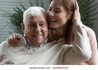 Close up headshot loving elderly father stroking overjoyed daughter head, family enjoying tender moment, two generations, excited mature man and young woman hugging, having fun together
