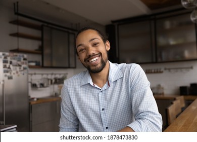 Close up headshot portrait of smiling African American man talk on video call on gadget. Happy millennial biracial male have webcam digital virtual conference online, engaged in web meeting.