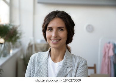 Close up headshot portrait of smiling successful Caucasian woman fashion designer or tailor pose in home office. Profile picture of happy confident stylist or architect look at camera work in atelier.
