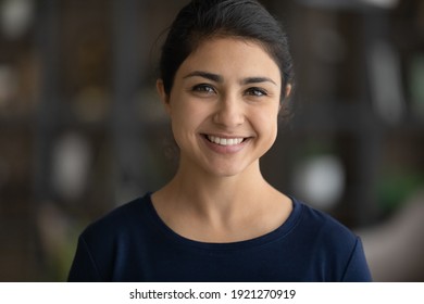 Close Up Headshot Portrait Of Young 20s Indian Woman Pose Look At Camera Feel Optimistic. Profile Picture Of Smiling Millennial Mixed Race Female Renter Or Tenant In New Own Home. Diversity Concept.