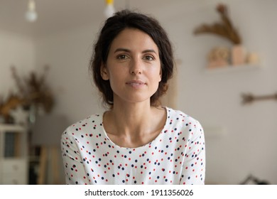 Close up headshot portrait of young Caucasian woman look at camera pose relax in new cozy home alone. Profile picture of millennial 20s female renter or tenant talk on video call or webcam conference. - Powered by Shutterstock