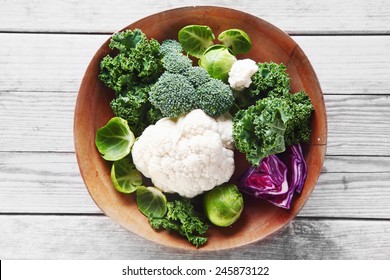 Close up Healthy Fresh Salad Ingredients with Broccoli, Cauliflower, Purple Cabbage and Brussels Sprout on Wooden Bowl, Placed on Wooden Table. - Powered by Shutterstock