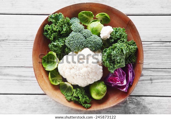 Close up Healthy Fresh Salad Ingredients with\
Broccoli, Cauliflower, Purple Cabbage and Brussels Sprout on Wooden\
Bowl, Placed on Wooden\
Table.