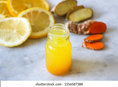 Close up of a healthy Ginger Lemon Turmeric Shot – ideal to boost the immune system during the winter. - Shutterstock ID 1556587388