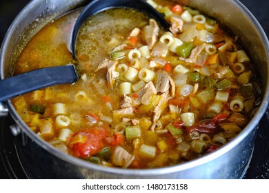 Close Up Of Healthy Nutritious Chicken Noodle Soup In Pot With Ladle