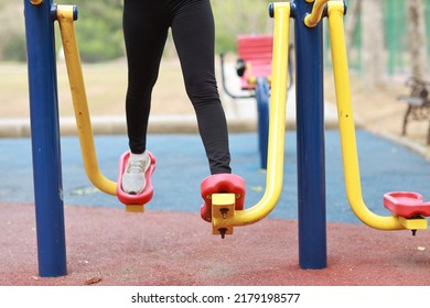 Close Up Healthy Young Asian Woman In Sportswear Relaxing On Public Exercise Machine Outdoor. 