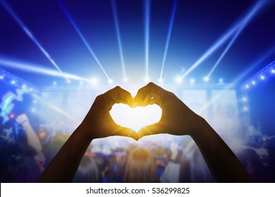 Close Up A Heart Shaped Hand  At Crowd Of People At During A Live Concert.