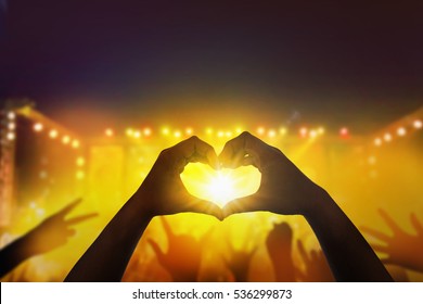 Close Up A Heart Shaped Hand  At Crowd Of People At During A Live Concert.